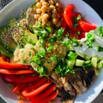 Vibrant vegetable bowl featuring chickpeas, bell peppers, mushrooms, and fresh greens.